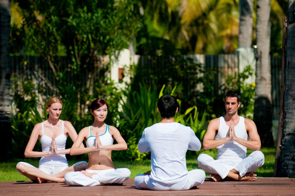 A group of friends practicing yoga outdoors